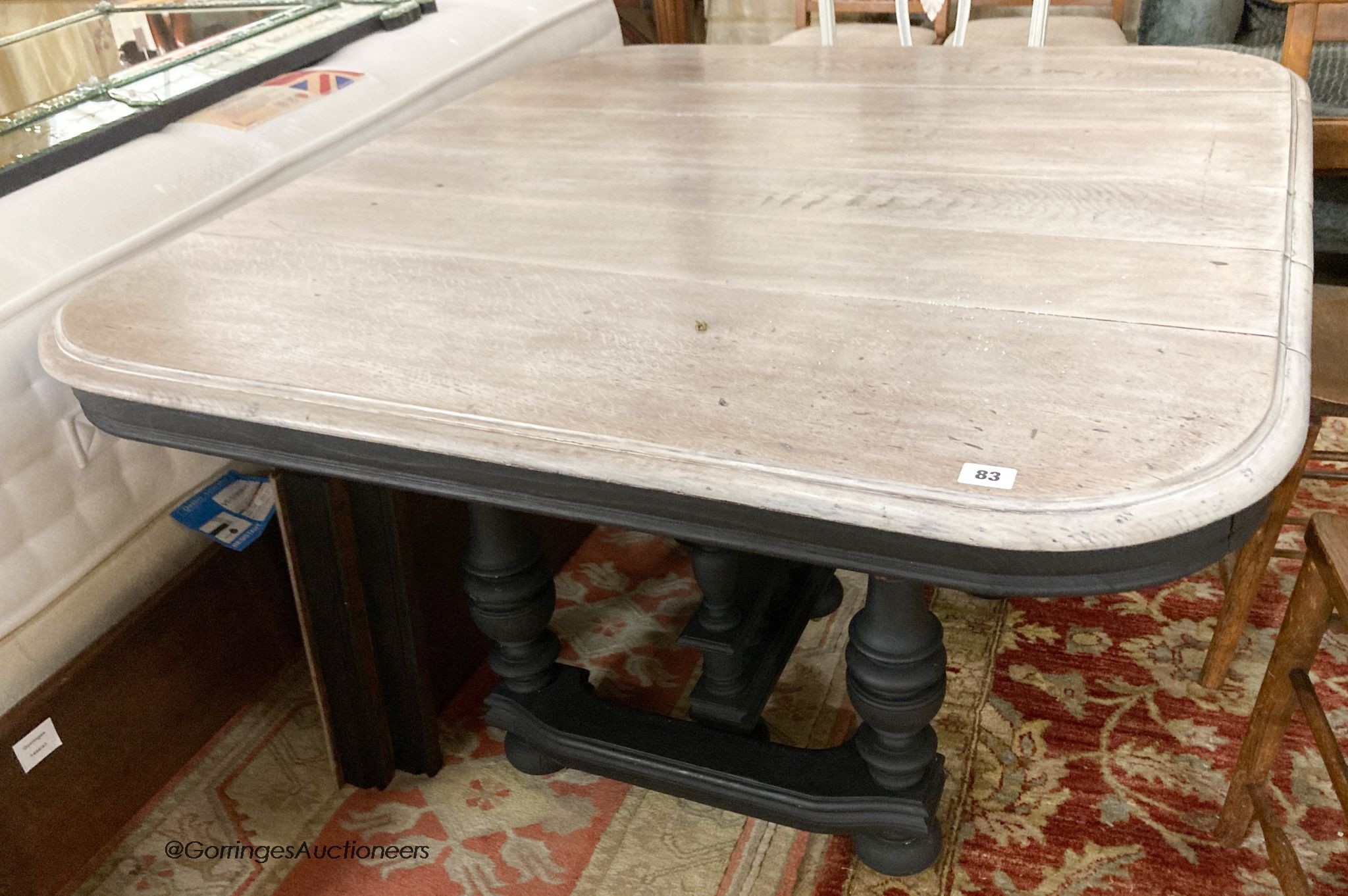 A 19th century French stripped oak and painted extending dining table, 210cm extended, two spare leaves, D.103cm H.71cm